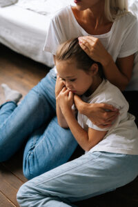 Mother comforting her daughter through growing pains.